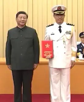 Xi Jinping and Dong Jun standing together facing the camera.