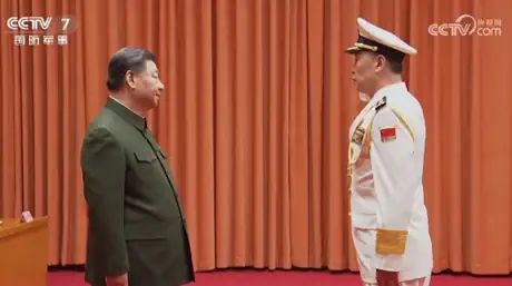 Xi Jinping and Hu Zhongming standing together facing each other.