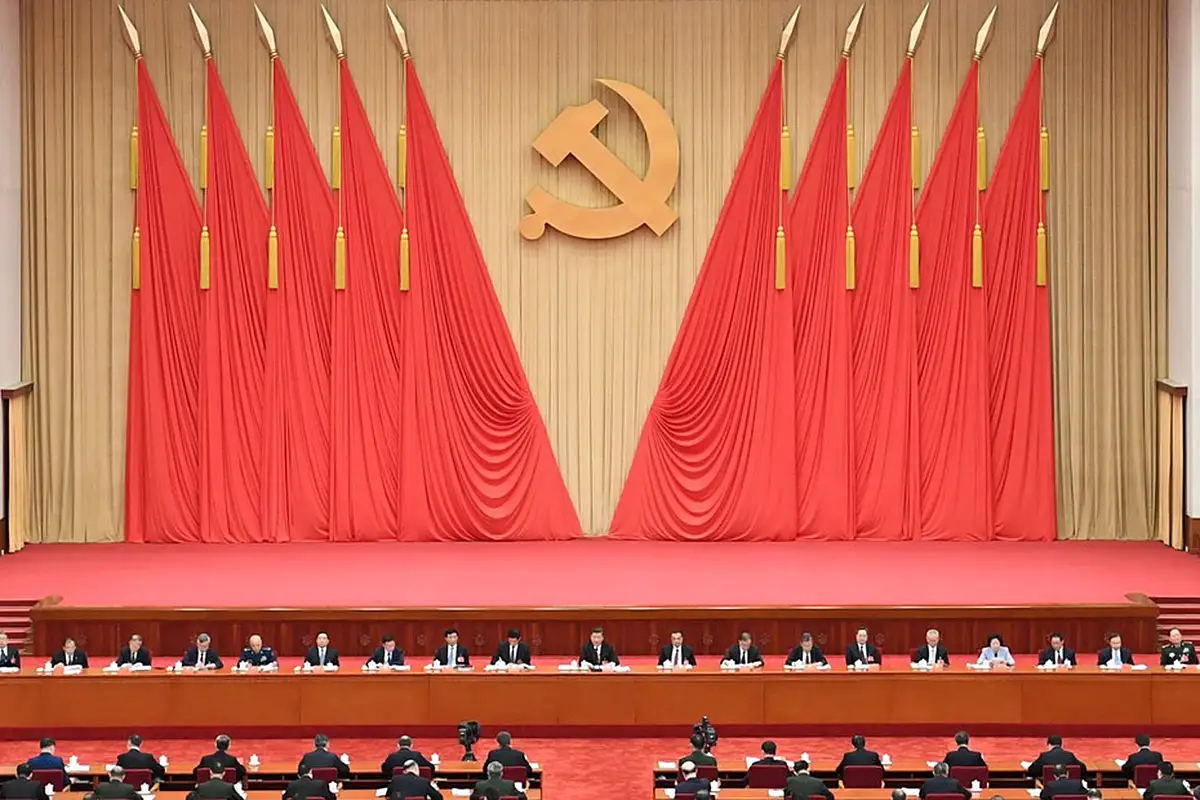 Stage with Chinese leaders and hammer and sickle on wall